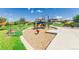 Community playground with colorful equipment, woodchip ground cover, benches, and lush green landscaping at 12941 Delaware St, Westminster, CO 80234