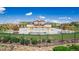 Community pool with pergola covered seating surrounded by lush landscaping and a wrought iron fence at 12941 Delaware St, Westminster, CO 80234
