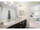Light-filled bathroom with double sinks and modern fixtures connects to a bedroom at 6143 Eldora St, Golden, CO 80403