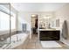 Elegant main bathroom with a soaking tub, vanity, and a walk-in closet at 6143 Eldora St, Golden, CO 80403
