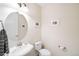 Cozy powder room with classic fixtures, including a pedestal sink and a decorative oval mirror at 6143 Eldora St, Golden, CO 80403