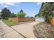 This detached garage features a new garage door, driveway, and a surrounding wood fence at 1801 S Eudora St, Denver, CO 80222