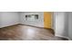 Spacious living room with hardwood floors and plenty of natural light, featuring a bright yellow front door at 1801 S Eudora St, Denver, CO 80222
