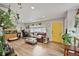 Bright living room featuring hardwood floors, a comfortable leather couch, and lots of plants at 1801 S Eudora St, Denver, CO 80222