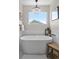 Bright bathroom featuring a modern freestanding tub, chandelier, and shiplap accents at 10570 Humboldt Peak Way, Parker, CO 80138