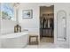 Bright bathroom with a modern freestanding tub, chandelier, and shiplap accents at 10570 Humboldt Peak Way, Parker, CO 80138