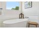 Bright bathroom featuring a modern freestanding tub and shiplap accents at 10570 Humboldt Peak Way, Parker, CO 80138