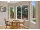 Sunny dining area with a wooden table, chairs, and large windows overlooking the backyard at 10570 Humboldt Peak Way, Parker, CO 80138