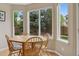 Sunny dining area with a wooden table, chairs, and large windows overlooking the backyard at 10570 Humboldt Peak Way, Parker, CO 80138