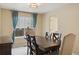 Dining room with a wooden table and chairs set, light fixture and window with curtains at 10570 Humboldt Peak Way, Parker, CO 80138
