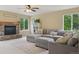 Spacious living room featuring a comfortable gray sectional sofa and a cozy stone fireplace at 10570 Humboldt Peak Way, Parker, CO 80138