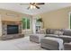 Living room featuring stone fireplace, a gray sectional sofa and large windows at 10570 Humboldt Peak Way, Parker, CO 80138