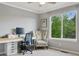 Comfortable home office area with a computer and decorative chair near a window with views of the backyard at 10570 Humboldt Peak Way, Parker, CO 80138