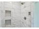 Elegant shower with white marble tile, mosaic niches, and modern fixtures at 10570 Humboldt Peak Way, Parker, CO 80138