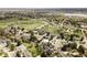 Aerial view of a peaceful neighborhood with tree-lined streets and nearby lake and green spaces at 7060 S Windsor St, Littleton, CO 80128