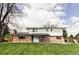 Expansive backyard boasts mature trees, lush grass, and a patio perfect for outdoor gatherings at 7060 S Windsor St, Littleton, CO 80128