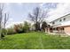 Expansive backyard with lush green lawn, mature trees, and a patio area perfect for outdoor living at 7060 S Windsor St, Littleton, CO 80128