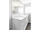 Bathroom featuring a large vanity with double sinks, granite countertop, and modern fixtures at 7060 S Windsor St, Littleton, CO 80128