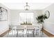 Elegant dining room with a modern chandelier, white table and chairs, and a stylish geometric patterned rug at 7060 S Windsor St, Littleton, CO 80128
