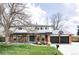 Charming two-story home featuring a red brick exterior, large front yard, and an attached two-car garage at 7060 S Windsor St, Littleton, CO 80128