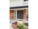 Inviting front entryway with brick facade, modern front door, and manicured landscaping at 7060 S Windsor St, Littleton, CO 80128