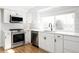 Modern kitchen with white cabinets, stainless steel appliances, subway tile backsplash, and a large window above the sink at 7060 S Windsor St, Littleton, CO 80128