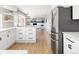 Open-concept kitchen featuring white cabinetry, stainless steel appliances, and a center island with bar stool seating at 7060 S Windsor St, Littleton, CO 80128
