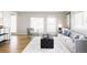 Spacious living room with hardwood floors, a gray sofa, and large windows offering plenty of natural light at 7060 S Windsor St, Littleton, CO 80128