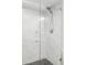 Modern shower features marble tile surround, glass door, and sleek chrome fixtures at 7060 S Windsor St, Littleton, CO 80128