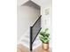 Staircase with black railing, neutral walls, and stylish decor at 7060 S Windsor St, Littleton, CO 80128