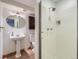 Bathroom featuring a pedestal sink, medicine cabinet, toilet, and enclosed shower stall with tile walls at 9057 E Oxford Dr, Denver, CO 80237