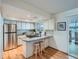 Bright kitchen with white cabinets, stainless steel refrigerator, breakfast bar, and hardwood floors at 9057 E Oxford Dr, Denver, CO 80237