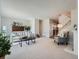 Bright living room features plush carpeting, a stylish sofa, and modern decor with a fireplace and staircase at 9057 E Oxford Dr, Denver, CO 80237