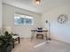 Bright office with a desk, two chairs, natural light, and a large clock at 9057 E Oxford Dr, Denver, CO 80237
