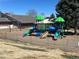 Community playground featuring slides and swings within a fenced area surrounded by mature trees at 9057 E Oxford Dr, Denver, CO 80237
