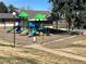 Community playground with slides, swings, and green awnings in a secure, fenced-in area at 9057 E Oxford Dr, Denver, CO 80237