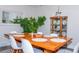 Dining room features a wooden table with seating for six, enhanced by a classic china cabinet and lush green plants at 10911 Tennyson Ct, Westminster, CO 80031