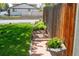 Front yard with lush lawn, flowerbed along a fence, and brick path at 10911 Tennyson Ct, Westminster, CO 80031