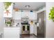 Well-lit kitchen with white cabinetry, stainless steel appliances, and leafy plants adding a touch of freshness at 10911 Tennyson Ct, Westminster, CO 80031