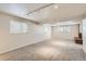 Spacious basement featuring neutral carpet, brick fireplace, natural light and track lighting at 2221 S Arbutus Ct, Lakewood, CO 80228