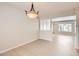 Open-concept dining room boasts tile floors, stylish chandelier, and natural light from the adjacent room at 2221 S Arbutus Ct, Lakewood, CO 80228