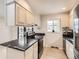 Modern kitchen featuring granite countertops, white cabinets, and stainless steel appliances at 2221 S Arbutus Ct, Lakewood, CO 80228