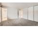 Spacious main bedroom with neutral carpet, closet, and access to the en-suite bathroom at 2221 S Arbutus Ct, Lakewood, CO 80228