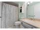 Well-maintained bathroom features a shower with a patterned curtain, a vanity, and a toilet at 7877 E Mississippi Ave # 607, Denver, CO 80247
