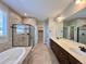 Luxurious bathroom featuring a soaking tub, glass-enclosed shower, double vanity, and elegant tile work at 9477 Market Ln, Parker, CO 80134
