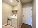 Well-equipped laundry room with modern washer and dryer units, shelving, and convenient access to an exterior door at 9477 Market Ln, Parker, CO 80134