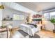 Bright bedroom with hardwood floors, exposed beams, large windows, and a tufted headboard at 1392 S Edison Way, Denver, CO 80222
