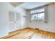 Bright, open bedroom with gleaming hardwood floors, wide window, and closet with paneled doors at 1392 S Edison Way, Denver, CO 80222