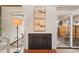 Cozy fireplace in living area, with exposed brick, modern art, and sliding glass doors to the backyard at 1392 S Edison Way, Denver, CO 80222