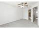 Bedroom showing a neutral carpet, ceiling fan and a view to the bathroom at 14465 E Hawaii Cir # A, Aurora, CO 80012